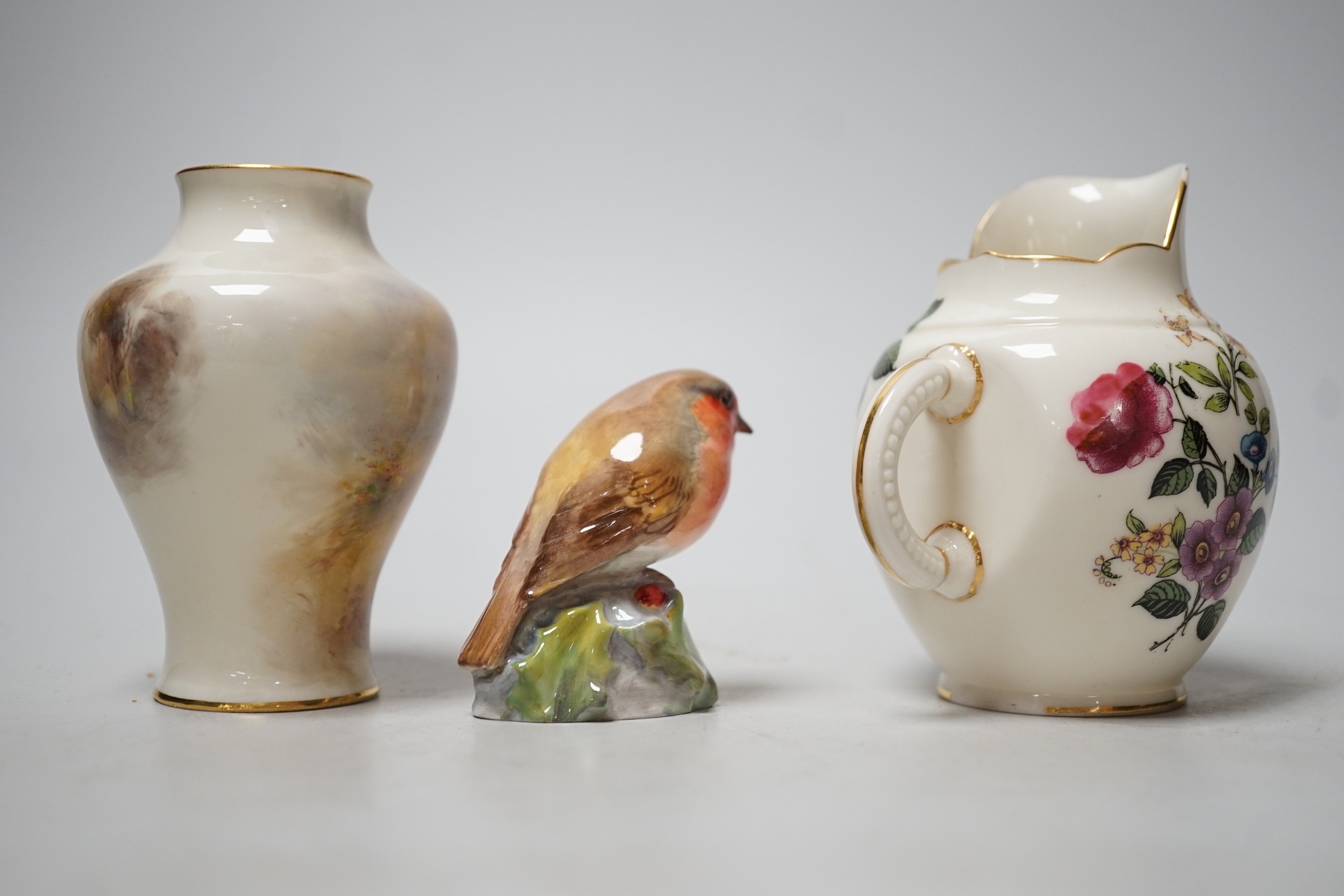 A Royal Worcester James Stinton vase with pheasant decoration, together with a Royal Worcester jug and a Royal Worcester robin figure. Tallest 10cm